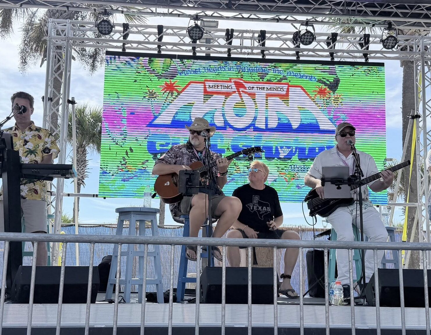 4 Outdoor band performance in front of a colorful Meeting of the Minds stage screen.